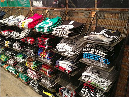 Do-It-Yourself T-Shirt Faceouts Line The Wall | Fixtures Close Up Clothing Booth Display, T Shirt Display, T-shirt Display, Vendor Booth Display, Store Display Ideas, Clothing Store Displays, Tshirt Display, Clothing Store Interior, Clothing Store Design