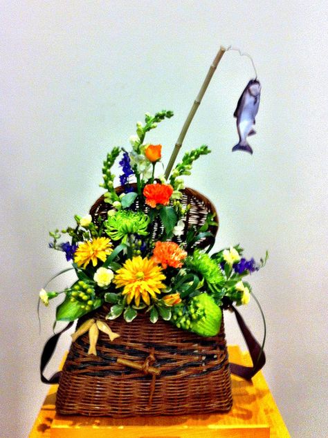 flowers in a fishing creel Fishing Arrangements, Fish Centerpiece, Fishing Wreath, Fishing Themed Wedding, Summer Flower Arrangements, Sympathy Arrangements, Grave Flowers, Casket Sprays, Cemetery Decorations