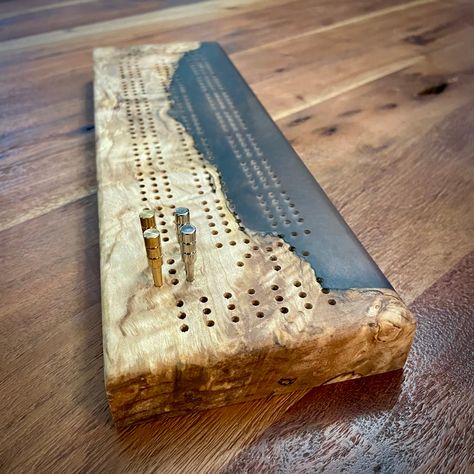 "A stunning handcrafted cribbage board that makes a very unique gift. Made from beautifully figured western Canadian maple and blended with a metallic espresso brown epoxy resin. The back of the board features a stylish magnetized storage compartment for storing the pegs. Includes 3 pairs of high-quality machined metal pegs (silver, gold and copper, 6 pegs total). Approximate dimensions: 14 1/2\" L x 4 1/2\" in W x 1\" H. Peg holes are drilled to 1/8 in.  Finished with all natural, food grade fi Cribbage Pegs, Machining Metal, Cribbage Board, Backgammon Set, Cnc Projects, Canadian Maple, Epoxy Resin Wood, Espresso Brown, Blink Of An Eye