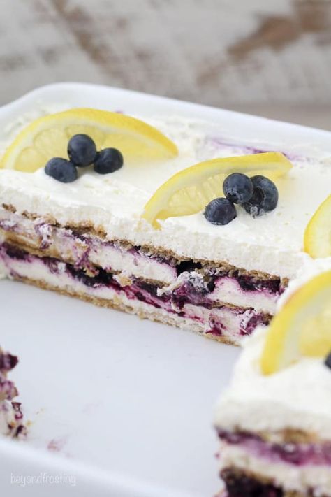 This Blueberry Lemon Cheesecake Icebox Cake is layers of honey graham crackers, a sweet blueberry sauce and a tangy lemon cheesecake. This no-bake dessert is the perfect for summer, and the homemade blueberry sauce is amazing! #iceboxcake #dessertlasagna #nobake #nobakedessert #blueberry #lemon #blueberrylemon Lemon Blueberry Lasagna, Graham Cake Recipe, Cheesecake Icebox Cake, Blueberry Lemon Cheesecake, Honey Graham Crackers, Graham Cake, Pan Desserts, Dessert Lasagna, Lemon Icebox Cake