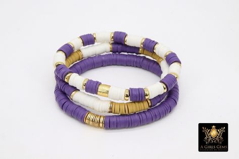 Purple and Gold Bracelet in Heishi Beads by Regina Harp Designs These bracelets are in a purple, white and gold colors with your choice of bracelet style. They can be made with our other bead colors as well; message us if you would like to customize your bracelet. If you need a smaller or extra large size in the bracelet, please leave us a note with your order. **SPECIFICATIONS** Measurements Approximately: Length is 6.5~7 inches Stones: 6 mm Heishi clay beads Quantity of Items: 1 bracelet unles Heishi Bracelet Lsu, Purple And Gold Bracelets, Bracelet Organization Ideas, Purple Heishi Bracelet Ideas, Purple Gold Bracelet, Purple Heishi Bracelet, Polymer Clay Bracelet Ideas Preppy, Purple Clay Bead Bracelet Ideas, Heishi Bracelet Diy