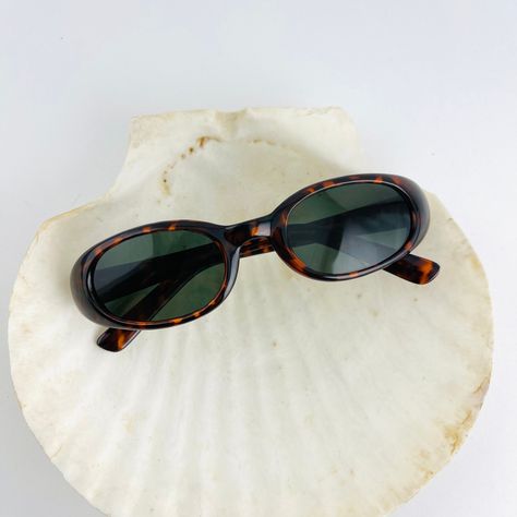 A flat lay of a pair of vintage 90s red tortoise frame oval sunglasses on top of a white seashell. Cotton On Sunglasses, Oval Tortoise Shell Sunglasses, 90s Style Sunglasses, 90s Sunglasses Vintage, Oval Sunglasses 90s, Indie Sunglasses, Classic Sunglasses Women, Italy Sunglasses, Sunglasses 90s