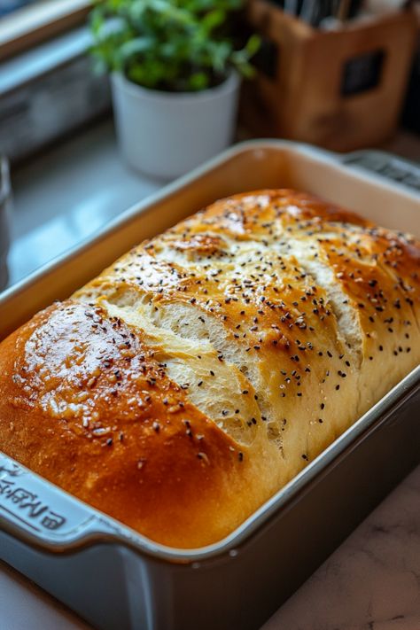 Freshly baked loaf of bread in a baking pan, topped with sesame seeds and crispy golden crust. Homemade Bread Machine Recipes Easy, How To Make Bread In Bread Machine, 3 Pound Bread Machine Recipes, Bread Machine Pretzel Bread, Sweet Bread Maker Recipes Easy, Mediterranean Bread Machine Recipes, Bread Bowl Recipe Bread Machine, Sugar Free Bread Machine Recipes, Bread Machine Bread Dough