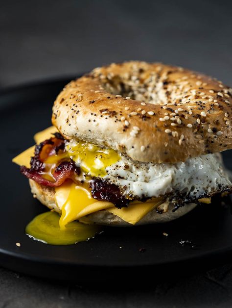 This Bagel Breakfast Sandwich is the perfect easy way to start the morning! Real deal thick bacon, fresh bagels, gooey cheese and sliced grilled onions truly make this the ultimate breakfast sandwich. Bagel Burger Ideas, Blueberry Bagel Sandwich, Begal Sandwich, Breakfast Bagel Sandwich Ideas, Bagel Recipe Sandwich, Bagel Sandwich Ideas, Bagel Burger, Breakfast Bagel Sandwich, Fresh Bagels