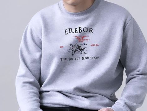 🐉🏔️THE LONELY MOUNTAIN 🏔️🐉 Heyy! New lort sweaters are coming! 🙌🏻 I hope u like the Erebor & the Hobbit inspired 🌿Middle Earth Collection🌿 A sweatshirt dedicated to the fans of The Lord of the Rings. Redhorizonstore.etsy.com 📣 #hobbiton #cozycottage #thelordoftherings #sudaderabordada #embroideredsweatshirts #elseñordelosanillos #middleearth #thefellowshipofthering #cozyvibes #erebor #thelonelymountain #lotrart #smaug #dragon #tolkienuniverse Lord Of The Rings Sweater, Smaug Dragon, Lonely Mountain, Geek Clothes, Lotr Art, The Lord Of The Rings, One Ring, Middle Earth, Embroidered Sweatshirts