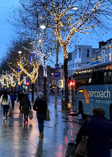 Illuminated trees on a city street with a bus parked beside a sidewalk Irish Christmas Aesthetic, Dublin Christmas Aesthetic, Dublin Winter Aesthetic, Winter In Ireland, Christmas Ireland, Dublin Winter, Dublin Christmas, Ireland Christmas, Dublin Map