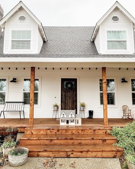 Farmhouse Is My Style on Instagram: “A beautiful white farmhouse with lovely dormer windows, a gorgeous wood stain on the front porch and beams, an eye catching rustic dark…” Dark Wood Front Door, White Siding Exterior, Wood Front Door, Wooden Rocking Chair, Porch Wood, White Porch, White Siding, Porch Windows, Rustic Porch