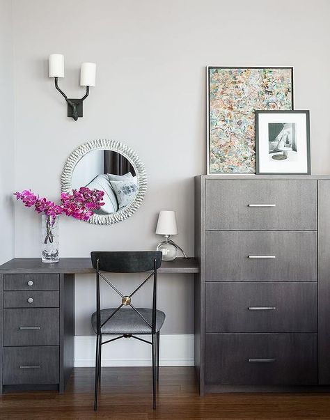 Chic bedroom boasts a gray wash make up vanity and desk combo paired with a black and gold chair placed under a silver sunburst mirror next to a tall gray wash dresser. Vanity And Desk Combo, Desk Dresser Combo, Gold Chairs, Home Bedroom Design, Dresser Desk, Dresser Vanity, Gold Chair, Vanity Design, Bedroom Desk