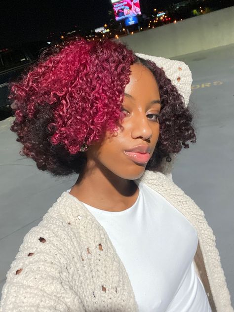 Fusha Hair Color Black Women, Magenta Curly Hair Black Women, Pink Hair Wax Natural Hair, Pink Hair Color Ideas For Black Women, Pink Peak A Boo Curly Hair, Dark Pink Hair Black Women, Dyed Natural Hair Pink, Pink Skunk Stripe Curly Hair, Pink Curly Hair Black Women