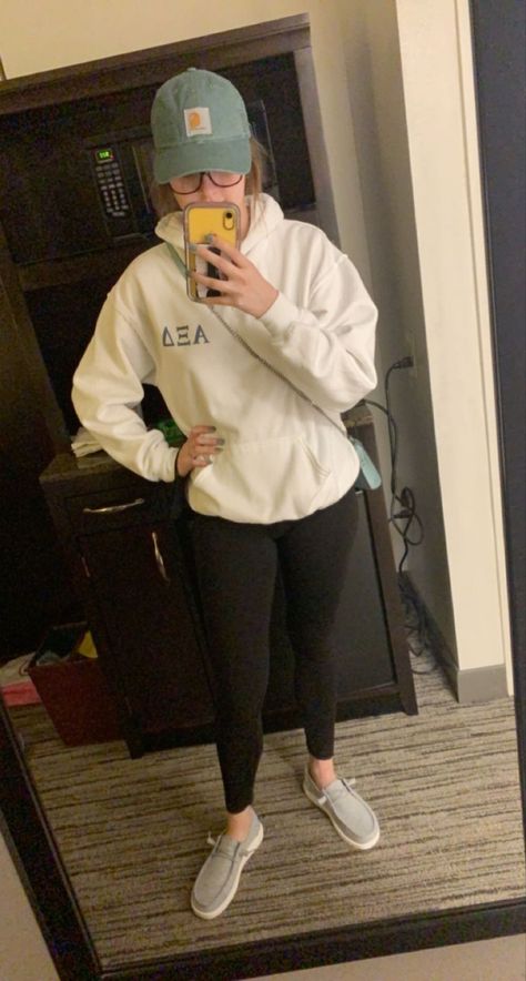 Sorority hoodie with black leggings and grey hey dude shoes topped with a sage green carrhart baseball cap Hey Dudes And Leggings, Outfits With Hey Dudes For Women Casual, Dresses With Hey Dudes, Fuzzy Hey Dudes Outfit, Black Hey Dudes Outfit Women, Cute Outfits With Hey Dudes, Black Hey Dudes Outfit, Hey Dude Outfits For Women, Grey Hey Dudes Outfit