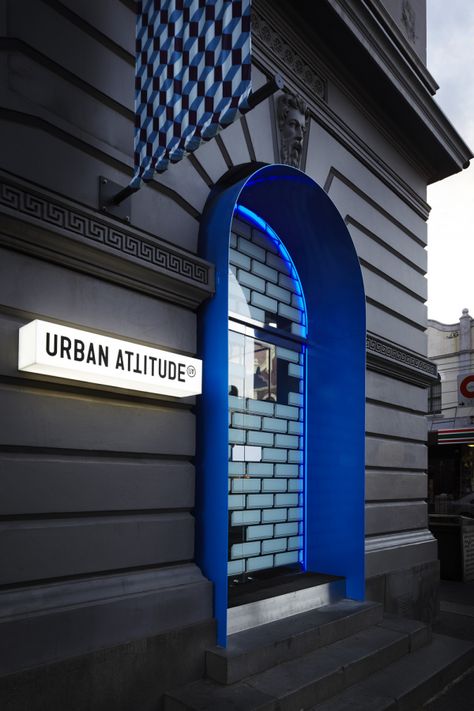 Urban Attitude is an eclectic giftware store renowned for the party environment of their established Acland Street and Chapel Street stores. The site selected to launch their new brand and flagship store was the heritage-listed former Fitzroy Post Office, located on a prominent corner in Fitzroy. HASSELL was commissioned to work in collaboration with Fabio Ongarato Design to create a ‘party’ atmosphere through an integrated interior and graphic design approach. The concept that resonated was... Modern Doorway, Retail Facade, Shop Facade, Storefront Design, Classic Building, Australian Interior Design, Interior Design Awards, Josef Albers, Entrance Design