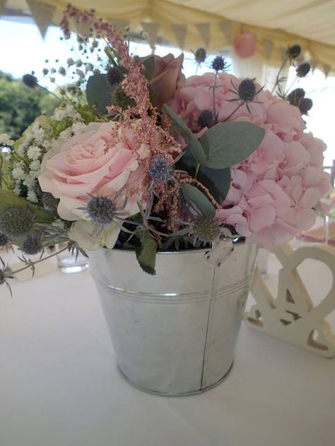 metal bucket centre piece arrangement Flowers In Tin Bucket, Flowers In Metal Buckets, Metal Bucket Centerpieces, Bucket Flower Arrangements, Bucket Centerpiece Ideas, Galvanized Buckets Wedding, Bucket Centerpiece, Anniversary Gift Baskets, Bridal Shower Bachelorette Party Ideas