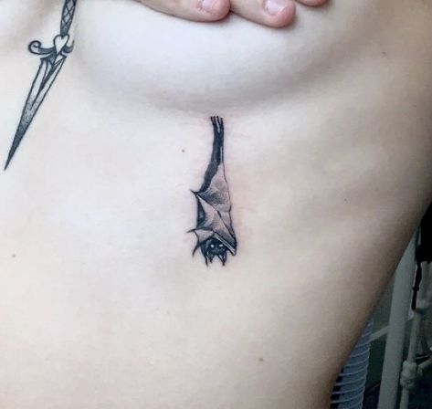 Aesthetic Bat Tattoo, Vampire Goth Tattoo, Tiny Vampire Tattoo, Cool Bat Tattoos, Bat Hanging Tattoo, Bat Tattoo Under Breast, Bat And Butterfly Tattoo, Wraparound Ankle Tattoo, Minimalist Gothic Tattoo