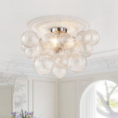 Add some sparkle and style to your ceiling with this 3-light ribbed glass bubble semi-flush mount. It features multiple clear ribbed glass shades that resemble bubbles floating in the air. The brass-finished metal frame adds a touch of elegance and contrast to the glass. The ribbed bubble semi-flush ceiling light is compatible with three E12 bulbs (not included). Light filters through the ribbed glass shade, refracting beautiful patterns on the ceiling. It is perfect for adding some glamour and Modern Flush Mount Ceiling Light, Wall String Lights, Floating In The Air, Light Filters, Glass Bubble, Bubble Lights, Semi Flush Ceiling Lights, Ribbed Glass, Light Fixtures Flush Mount