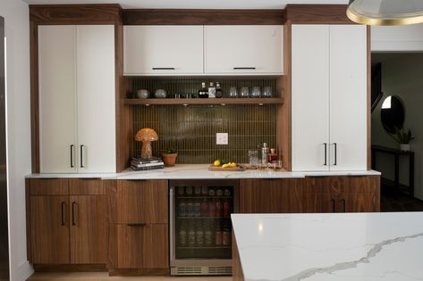 70's charm meets modern style. ✨ Rich walnut cabinetry adds warmth and character, while the sleek white shaker cabinets brighten the space with a fresh, airy vibe. The oversized island? Perfect for everything—from family breakfasts to late-night snack sessions. A playful blend of retro design and everyday functionality, designed to keep up with busy family life. . . . Dealer: @studiomkitchenandbath Designer: Bre Perrigo Coffee Maker Design, Shaker Cabinet Door Styles, Modern Dry Bar, Bar Remodel, Dining Room Buffet Table, White Upper Cabinets, Japanese Tile, 70s Kitchen, Bath Showroom