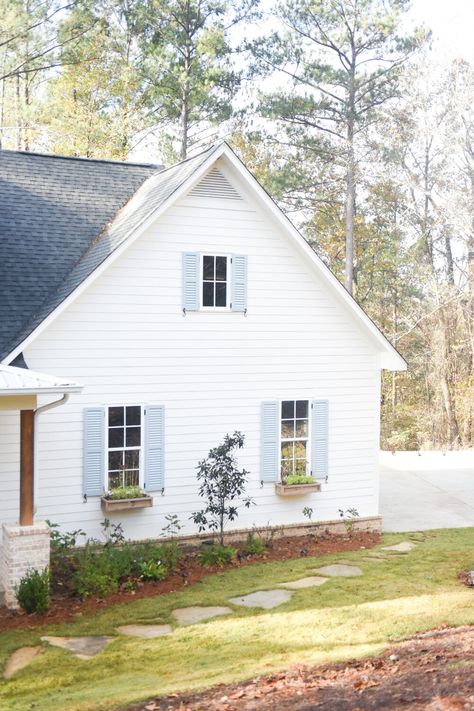 White Cottage Blue Shutters, White Farmhouse With Blue Shutters, White Brick House With Blue Shutters, Pale Blue Shutters White House, White House With Light Blue Shutters, White Farmhouse Blue Shutters, White Siding With Shutters, White Farmhouse Shutters, White Farmhouse With Shutters