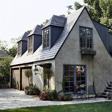 The perfect Tudor-style garage and guesthouse updated beautifully with a lively blue paint color for the trim. Tumbled Stone House Exterior, Dormers Ideas Exterior, Cottage House Exterior, Inlaw Suite, Casa Garage, Carriage House Garage, Garage Door Styles, European Cottage, Small Cottage Homes