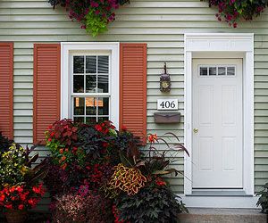 Outdoor lighting tips Orange Shutters Exterior, Potatoe Plant, Orange Shutters, Colorful Shutters, Coral Door, Red Shutters, Grey Siding, Shutter Colors, Plant Arrangement