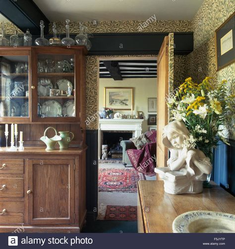 Download this stock image: William Morris green Willow Pattern wallpaper in old fashioned dining room with a glass front dresser - F5JYTP from Alamy's library of millions of high resolution stock photos, illustrations and vectors. William Morris Willow Wallpaper, Willaim Morris Wallpaper, William Morris Wallpaper Willow Bough, William Morris Willow Bough, William Morris Willow, Willow Pattern, Dining Room Inspiration, Decanters, Dream House Decor