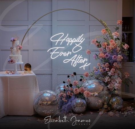 Disco balls and florals ✨The most beautiful cake table backdrop including our Neon 'Happily Ever After' Sign on Gold Moorgate frame 🌸🌿 Florist @rootedinrosemary Planner @emmareeveweddings Venue @the_great_house Cake @verityrosecakes Disco Ball Wedding Backdrop, Luxury Event Decor, Cake Table Backdrop, Disco Cake, Table Backdrop, Disco Wedding, Cake Table Decorations, House Cake, Elizabeth James