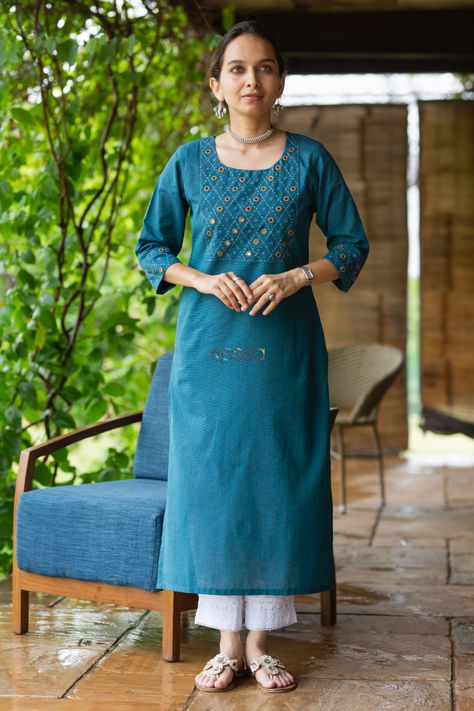 Rabhya is tailored out of luxurious 100% south cotton which is celebrated for its unique natural texture. The smart round neck line of the kurta is given a lively touch with dainty mirror embroidery and minimal Kantha work on the yoke. The 3/4th sleeves and a side pocket adds to the functional chic vibe of this beauty. It is the epitome of smart Indian wear for work. Contrast this kurta with lace salwar for perfect look. Faux Jacket, Mirror Embroidery, Indigo Prints, Kurti Designs Latest, Kurta Neck Design, Kurta Dress, Cotton Kurti Designs, A Line Kurta, Kantha Work