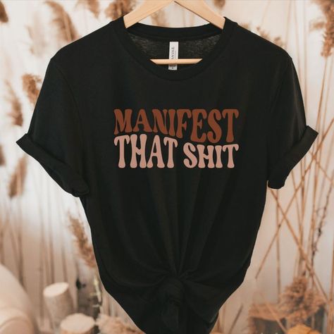 Manifestation Shirt, Retro Apparel. Manifest That Shit T Shirt. Law of attraction vibes. #Retro #Manifest #Manifestation #Etsy #SupportSmallBusiness 💗 Spiritual Graphic Tees, Spiritual Tee Shirts, Manifest Tshirt, Quote Tshirts, Cheap Spiritual Graphic Print T-shirt, White Spiritual Graphic T-shirt, Fall Sweatshirt, Pullover Sweatshirt, Trendy Outfits