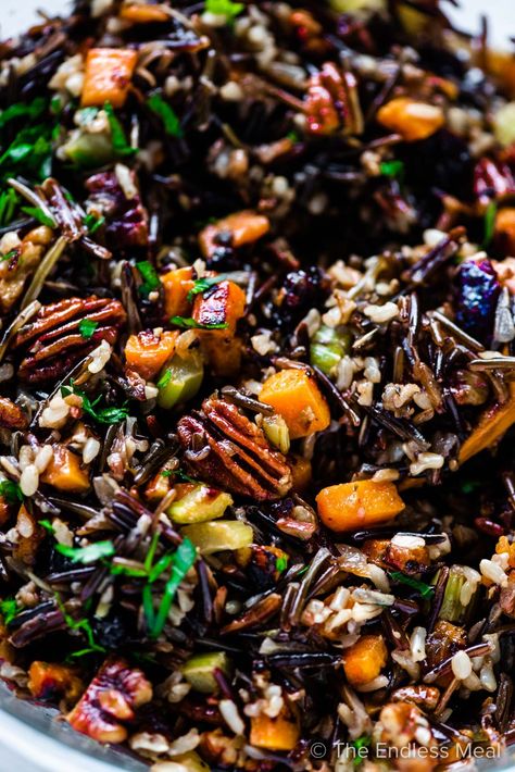 PIN TO SAVE! Our favorite wild rice stuffing is made with a wild rice blend cooked in a flavorful broth then mixed with cranberries, pecans, and sweet potatoes. #theendlessmeal #wildricestuffing #wildricepilaf #ricepilaf #wildrice #ricestuffing #stuffing #dressing #thanksgiving #thanksgivingrecipe #christmas #christmasdinner Wild Rice Sausage Casserole, Wild Rice Sausage Stuffing, Wild Rice Stuffing Thanksgiving, Seasoned Wild Rice, Wild Rice Dressing, Stuffing With Cranberries, Rice Dressing Recipe, Wild Rice Stuffing Recipes, Christmas Stuffing Recipe