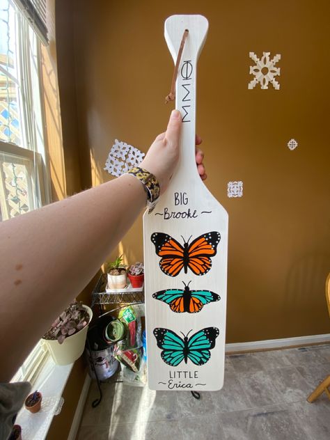 This is a white paddle. There are three butterflies. The top one is orange. The bottom is teal. The middle has both. Butterfly Sorority Paddle, Cute Sorority Paddles, Sorority Paddles, Phi Sigma Sigma, Sorority Big Little, Our Relationship, Paddles, Big Little, Sorority