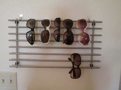 Sunglass display - IKEA Hackers ~ Needed a quick, cheap way to hang your sunglasses?…Ikea hack comes through! 3M Command hooks (no damage to the apt walls) and a little used IKEA LÄMPLIG Trivet (cooling rack) Read more at http://www.ikeahackers.net/2014/07/sunglass-display.html#kWFkTjLTDMr8vDmQ.99 Ikea Trivet, Sunglass Hanger, Sunglass Rack, Diy Sunglasses Holder, Wall Display Ideas, Sunglasses Rack, Sunglass Display, Diy Sunglasses, Ikea Organization Hacks