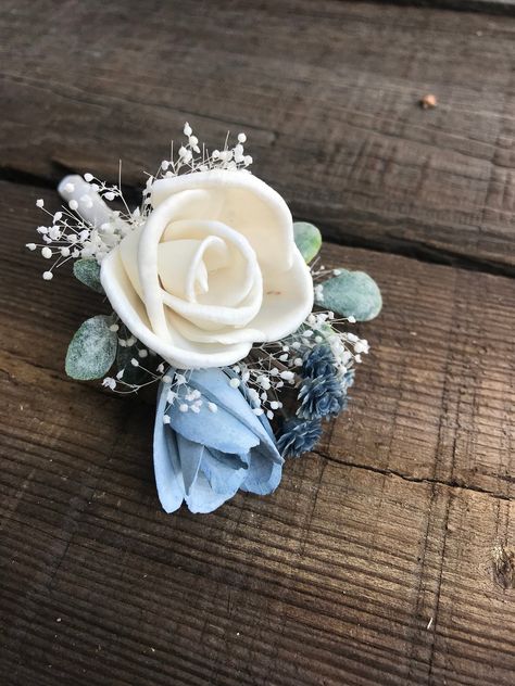 Sola wood flower boutonniere for groom or groomsmen by the Paisley Moon on Etsy. Natural ivory sola wood flower with rose bud dyed in a dusty blue shade with greens and filler. Stem is wrapped in ivory satin and finished off with satin ribbon knot. READY TO SHIP items here... https://www.etsy.com/shop/thepaisleymoon?ref=seller-platform-mcnav&section_id=5398474 Made to order boutonnieres in any color here... https://www.etsy.com/shop/thepaisleymoon?ref=seller-platform-mcnav&section_id=174 Dusty Blue And Sage Green Boutonniere, Blue Boutonniere Wedding, Dusty Blue Boutonniere, Copper Wedding Flowers, Wood Wedding Flowers, Corsage For Men, Boutineer Wedding, Wedding Centerpeices, Sage Green Wedding Theme