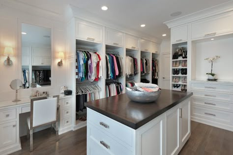 Fabulous walk-in closet features pull up cabinets stacked over double stacked clothes racks across beside a built-in dressing table paired with a white leather and chrome vanity chair under frameless vanity mirror illuminated by Thomas O'Brien Jonathan Sconces. Walk In Closet With Vanity, Closet With Vanity, Master Closet Layout, Small Master Closet, Make Up Tisch, Master Closet Design, Master Closet Organization, Closet Vanity, Walking Closet