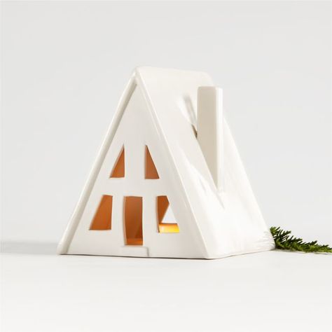 When filled with a glowing tealight, our small white ceramic A-frame house with cutout windows creates the inviting look of a light-filled dwelling. The snow-white, Scandinavian-inspired house boasts a clean, minimalist style that suits modern winter holiday decor. Combine with our other architectural styles to create a cozy village on your mantel, buffet or dining room table. A Crate & Barrel exclusive, each collectable ceramic house is debossed on the back with its architectural style and the Clay Gifts, Wood Reindeer, Flameless Tea Lights, Modern Holiday Decor, Wood Centerpieces, Small Collectibles, Wrapping Presents, Clay Houses, Frame House