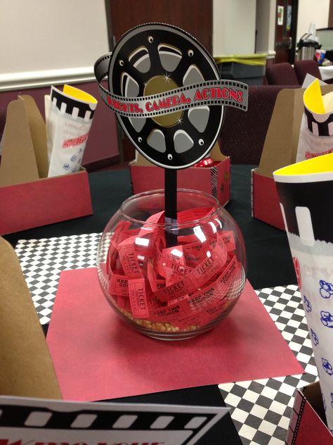 Movie theatre themed decor used for our big annual training. These are the centerpieces in each table - a fish bowl with popcorn kernels, tickets, and a movie reel. Also used scrapbook paper as a background to set the centerpiece on. Movie Party Centerpieces, Movie Themed Table Centerpieces, Hollywood Birthday Parties, Oscars Party Ideas, Cinema Party, Red Carpet Theme, Dance Theme, Hollywood Birthday, Movie Birthday Party