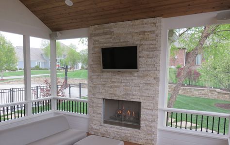 Vaulted Ceiling Porch Featuring a Fireplace with Mounted Television - Design Ideas - Archadeck Television Design, Porch With Fireplace, Outdoor Stone Fireplaces, Deck Fireplace, Porch Kits, Screened Porch Designs, Porch Fireplace, Knee Wall, Fireplace Facade