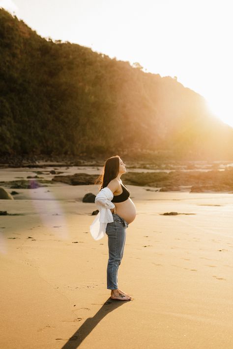 A gorgeous golden hour back lit image from a recent Sunset Maternity session in Raglan New Zealand. - Photographed by Hamilton New Zealand Maternity and Newborn Photographer Catherine Smith Photography Maternity Beach Photoshoot Jeans, Maternity Photo Jeans And Shirt, Jeans And Shirt Maternity Shoot, Light Blue Maternity Dress Photoshoot, Jeans Beach Maternity Shoot, Boardwalk Maternity Photos, Beach Sunset Maternity Photoshoot, Maternity Photography In Jeans, Maternity Aesthetic Outfit