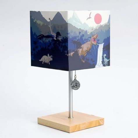 A Dinosaur Desk Lamp From Jurassic World Dominion Measures 14” Tall Rectangular Shade Is Covered With Scenes Of Dinosaurs Base Features A Square Wood Design Pull Is A Medallion Featuring The Tyrannosaurus Rex Head From The Jurassic World Logo Uses 40w Incandescent Or 9w Energy-Efficient Led Bulb (Included) With A Standard E26 Base Ac Mains Powered For Fans Of Dinosaurs Ages 12 And Older Dinosaurs Coexist With Humans In The Universe Of Jurassic World Dominion? Better Leave The Light On, Just To B Dinosaur Boys Room Target, Jurassic World Logo, Dinosaur Age, Dinosaur Bedroom, Jurassic World Dominion, Kids Play Set, Baby Activity Center, Plant Book, Task Lamps