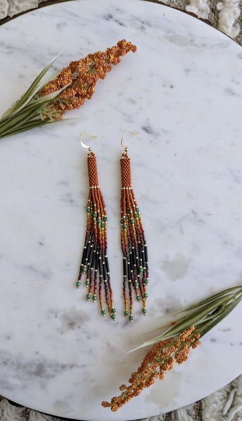 Change of Seasons 🍂 For those wild at heart, made with love.  Beautiful handmade orange tassel beaded earrings with Picasso turquoise accents and black bugle beads throughout. Made with high quality delica seed beads and fire polished beads. Gold plated stainless steel hooks. Métis Beading, Delica Beaded Earrings, Bead Bottle, Indian Beadwork, Diy Seed Bead Earrings, Fall Accents, Beadwork Designs, Beaded Earrings Diy, Turquoise Accents