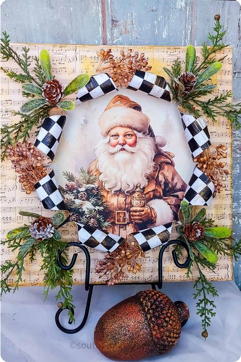 Christmas-themed picture of Santa Claus surrounded by a wreath with pinecones and black-and-white checkered ribbon. Break Out Canvas, Christmas Canvas Art Diy, Busted Canvas, Diy Christmas Canvas, Unique Art Projects, Christmas Canvas Art, Altered Canvas, Mod Podge Crafts, Christmas Crafting