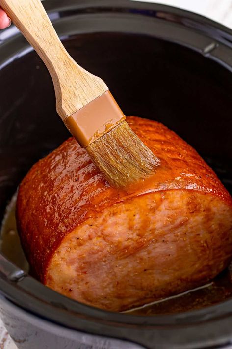 Finished ham being brushed with juices in slow cooker. Slow Cooker Pre Cooked Ham, Semi Boneless Ham In Crockpot, Crockpot Ham And Pineapple Recipes, Sweet Southern Slow Cooker Ham, No Bone Ham Recipes, Honey Ham Glaze Recipe Crockpot, How To Cook A Bone In Ham In Crock Pot, Ham In A Crockpot Slow Cooker, Best Ham In Crockpot Recipe