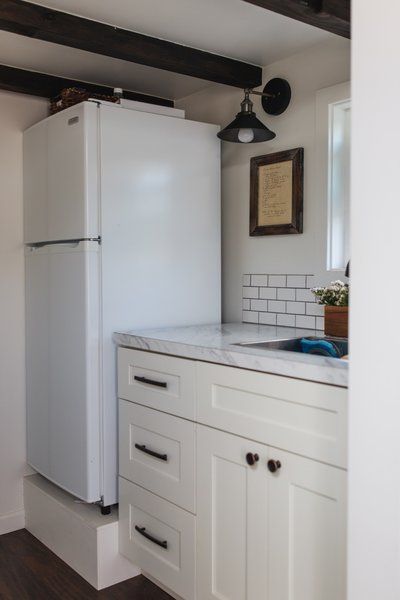 A Vissiani refrigerator stands next to the kitchen's formica countertops. The lights are from Ecopower. Refrigerator Stand, Cabinet Refrigerator, Off Grid Tiny House, Kitchen Cost, Basement Living, Formica Countertops, Laminate Counter, Tiny House Layout, Drop In Sink