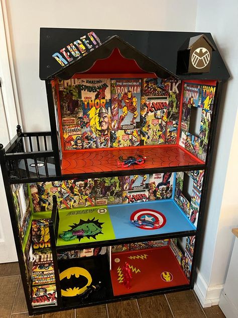 Black dolls house with superhero theme inside include Ironman, captain America, the hulk and Batman Toddler Boys Room Marvel, Superhero House Diy, Marvel Toy Storage, Marvel Playroom Ideas, Diy Superhero Bedroom, Superhero Playroom Ideas, Diy Superhero House, Superhero Themed Room, Superhero Dolls House