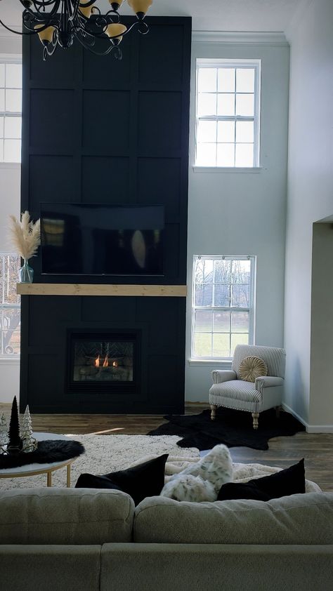 Black Fireplace High Ceiling, Black Accent Wall Living Room With Fireplace, Blacked Out Fireplace, Black High Ceiling Living Room, Very Tall Fireplace Wall, Black Wainscoting Fireplace Wall, Modern Black Tile Fireplace Wall, Tall Fireplace Wall High Ceilings Black, Black Surround Fireplace