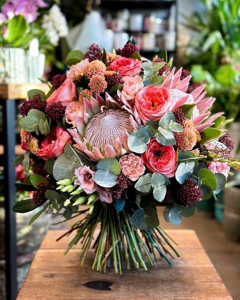 Mateusz Wasak on Instagram: "Let the depth and warmth of this stunning bouquet inspire a celebration of resilience and beauty. From the intricate protea to the soft whisper of eucalyptus, each bloom represents the layers and complexity that make every journey unique 🌺🍃 • • #mattflorist #masterflorist #eucalyptus #chrysanthemum #carnation #protea #lisianthus #skimmia #rose #bukiet #floral #florysta #bouquet #lovemyjob #warsaw #boywithflowers #florist #florystawarszawa #floralinspiration #флорист #флористика" Delphinium Bouquet, Protea Bouquet, South Africa Wedding, Africa Wedding, Dark Color Palette, Wedding Vibes, Delphinium, Chrysanthemum, Warsaw