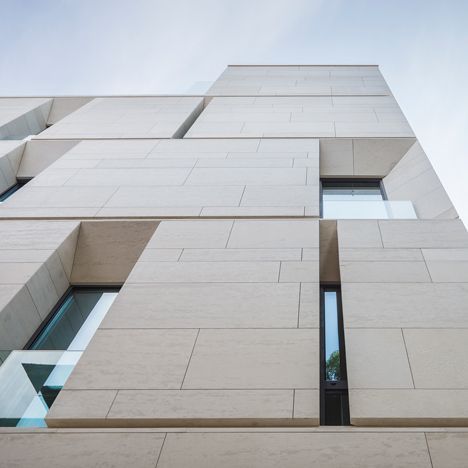 Angled window reveals and balconies interrupt the smooth limestone facades of this apartment building in Bucharest, Romania, by local architects ADNBA.. Apartment Building Architecture, Apartment Facade, Limestone Cladding, Apartment Entryway, Building Stairs, Facade Architecture Design, Stone Facade, Stylish Apartment, Apartment Architecture