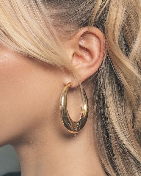 Turn heads no matter where you are! These sleek open hoop earrings are sure to add shine to all of your favorite looks. Available in gold and silver tones. Materials: 14K gold or rhodium plated brass Features: 2.1" hoop, 0.2-0.5" thickness, Lead & Nickel free, post back Thick Golden Hoop Earrings, Big Gold Hoops Aesthetic, Chunky Gold Jewelry Earrings, Gold Loop Earrings, Hoco Jewelry Gold, Big Hoop Earrings Outfit, Earings Piercings Aesthetic, Sade Style, Gold Hoop Earrings Aesthetic