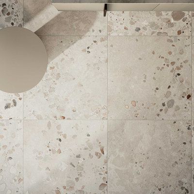 Cocci by Fioranese Ceramiche is an 36" x 36" Italian Textured Terrazzo Look Porcelain Floor and Wall Tile. This collection takes its inspiration from a Sicilian sandstone, with pebbles, stones, and rocks incorporated into it. The end result is a naturally uneven stone-effect porcelain stoneware featuring a mix of on-trend shades and deliberate color contrasts that are never too over the top. The presence of these uneven pebbles is highlighted by the MATTER onTOP technology, which allows us to ov Cream Square Tile Bathroom, Terazzo Floor Bathroom, Short Backsplash, Terrazzo Flooring Kitchen, Italian Tile Backsplash, Grey Terrazzo Floor, Large Shower Tile, Stone Tile Bathroom, Terrazzo Tile