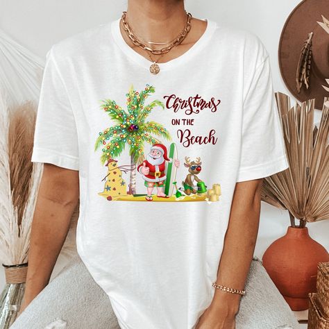 "This Christmas on the beach family shirt is perfect for yourself or family members and friends who loves Xmas holiday season in your life. Great gift for Birthday, Christmas vacation, or any occasion to celebrate! Add this tropical Christmas t-shirt to your holiday wardrobe. All of our shirts are made with the highest quality materials and are super soft and cozy! Below are some additional details on ordering. HOW TO ORDER 1-Please review all the information provided before placing an order 2- Beach Christmas Tshirt Ideas, Christmas Beach Vacation Shirts, Beach Christmas Tshirts, Beach Season Holiday Cotton T-shirt, Carribean Christmas Shirt, Christmas Palm Tree, Hawaii Christmas, Family Pjs, Tropical Outfit