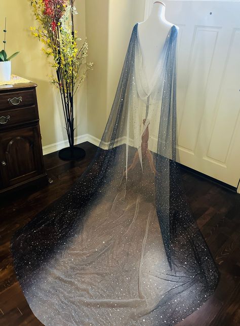 "Save yourself time and money by downloading your free \"Veil Guide\" by copying and pasting this link: https://mailchi.mp/7293feff861f/veilguide A modern take on the classic wedding veil, this extra sparkly cape veil was designed for unconventional brides who want to show off their fun personality. It gently transitions from a white color to a navy blue. Made from soft sparkly fabric with a generous sprinkling of silver stars, this detachable cape / veil can be worn in many different ways. It e Stars Wedding Veil, Silver Wedding Veil, Navy Blue And Silver Dress, Dark Blue Wedding Dress Brides, Blue Embroidered Wedding Veil, Star Veil Wedding, Cape Wedding, Night Sky Wedding Dress, Navy Wedding Dress Brides