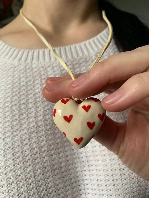 "💖   Ceramic Heart Pendant in White Clay, Necklace with Small Red Hearts 🌹🤍 Express your love with our exquisite Ceramic Heart Pendant, crafted from pure white clay and adorned with small, vibrant red hearts. This pendant is not just an accessory; it's a wearable declaration of love, perfect for lovers, mothers, or anyone who cherishes the symbol of affection. 🌟❤️ 🎨 Artisan-Crafted Romance: Meticulously handcrafted, this beige ceramic pendant is a testament to the artistry of clay craftsman Heart Necklace Clay, Ceramic Heart Pendant, Ceramic Heart Necklace, Clay Heart Necklace, Clay Heart Ideas, Handmade Clay Gifts, Clay Charm Necklace, Clay Necklace Pendant, Ceramic Accessories