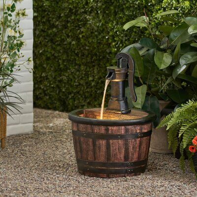 Williston Forge Add a touch of finesse and gracefulness to your outdoor space in one fell swoop. Our garden fountain features a calm waterfall flow that continuously circulates using an included pump, bringing a playful aura to any backyard or patio. this decorative accessory offers a weather-resistant structure that allows outstanding attention to detail. Finished with a charming barrel and pump design with enchanting underwater lights, our water fountain is sure to add a touch of whimsy to you Whiskey Barrel Fountain, Water Pump Fountain, Pump Fountain, Bnb Ideas, Water Fountain Design, Underwater Led Lights, Well Cover, Homes Inside, Outdoor Patio Designs